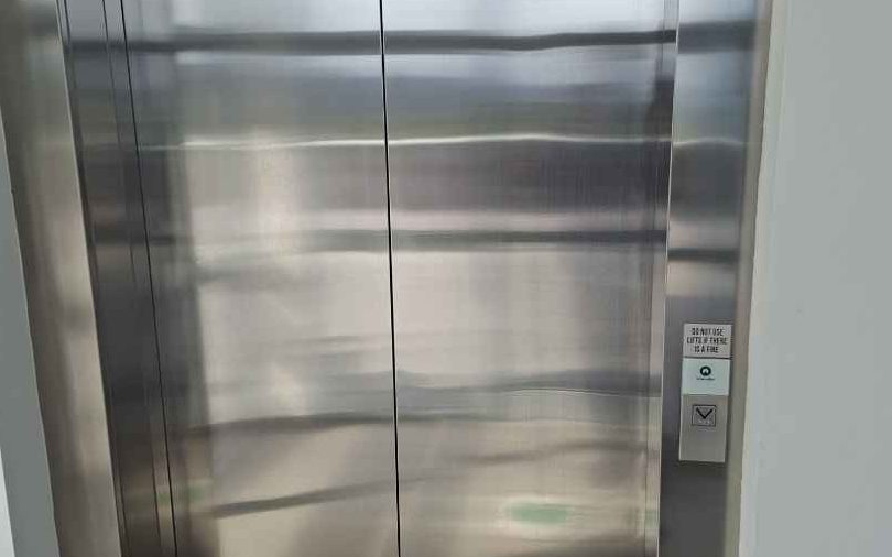 Polished lift doors in a Central Coast strata building cleaned by Coasties